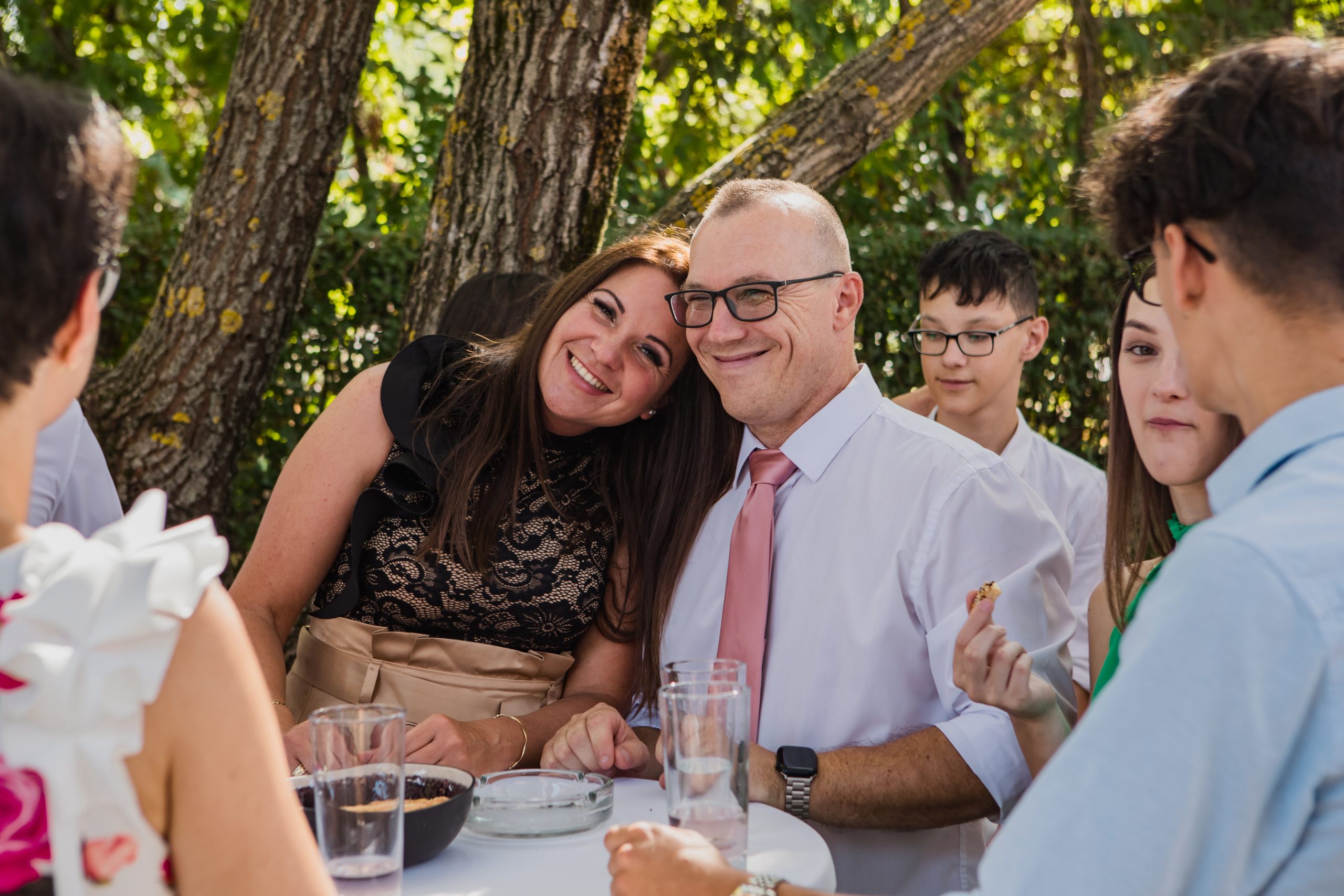 Vendégvárás az Eventgarden, mosolygós arcok a fák előtt.