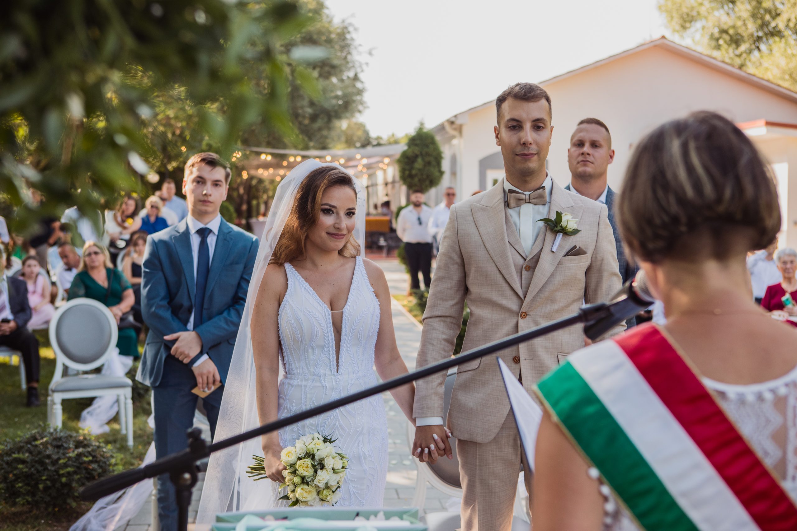 A szertartásvezető beszél a polgári szertartáson a násznéppel szemben.